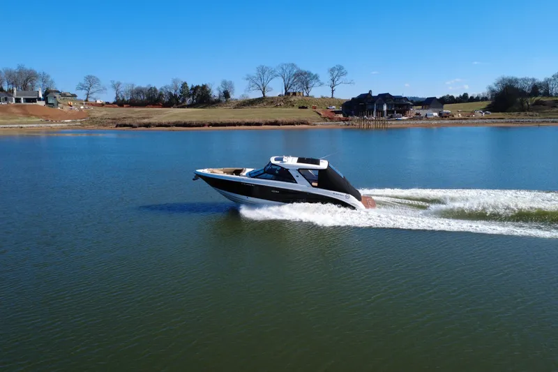 Slide: The Image of 2022 Sea Ray SLX 400 cruising on a serene lake under a clear blue sky. - 3