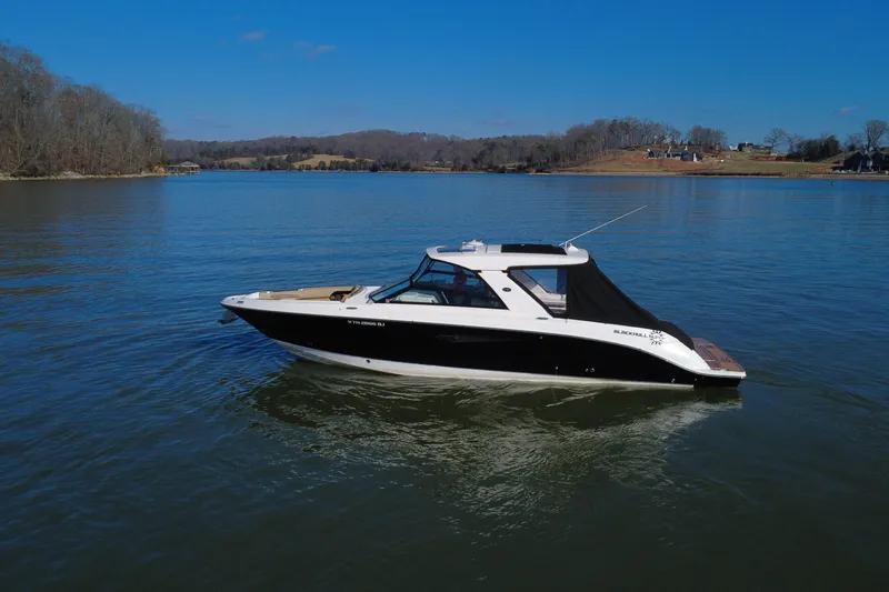Slide: The Image of 2022 Sea Ray SLX 400 boat on a calm lake under clear blue skies. - 30