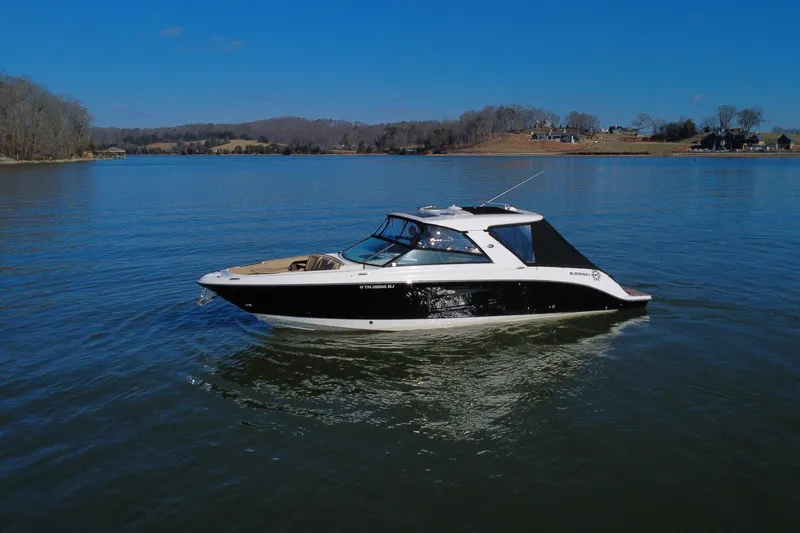 Slide: The Image of 2022 Sea Ray SLX 400 boat cruising on a serene lake under a clear blue sky. - 31