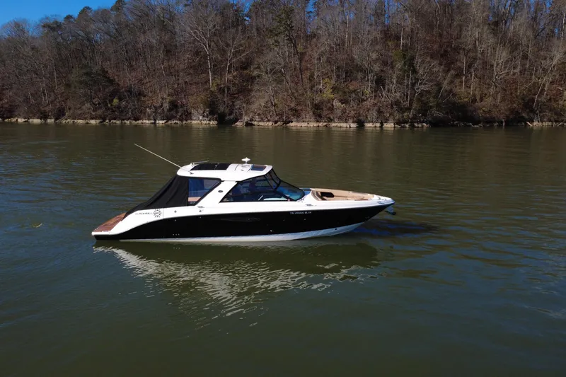 Slide: The Image of 2022 Sea Ray SLX 400 boat on calm lake with forested shoreline. - 32