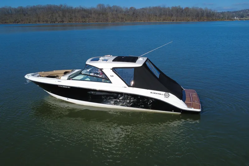 Slide: The Image of 2022 Sea Ray SLX 400 boat on calm lake with wooded shoreline. - 34
