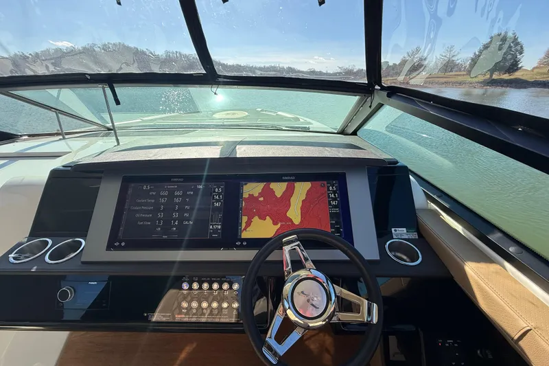 Slide: The Image of 2022 Sea Ray SLX 400 dashboard with navigation display and steering wheel on a sunny day. - 36