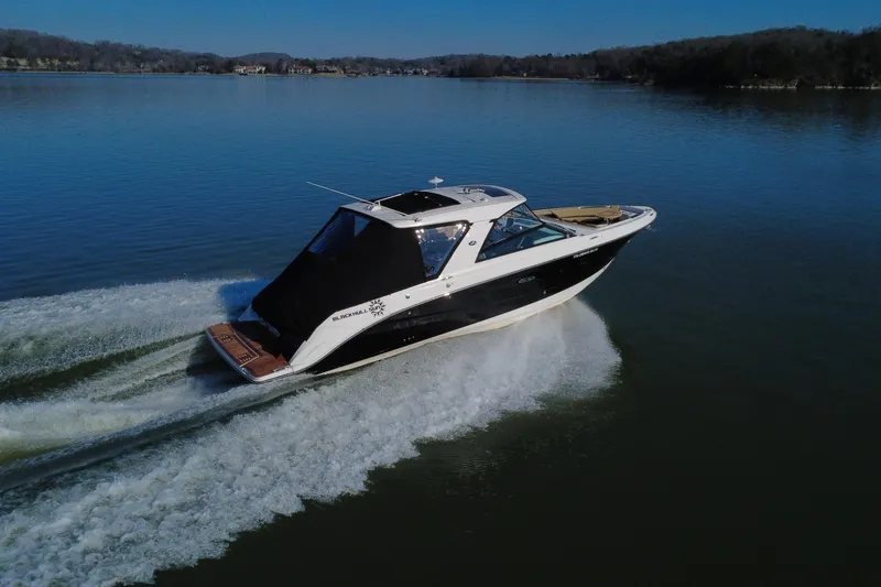 Slide: The Image of 2022 Sea Ray SLX 400 cruising on a calm lake under clear skies. - 4