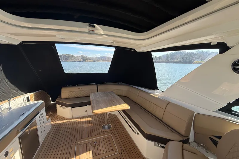 Slide: The Image of Luxurious 2022 Sea Ray SLX 400 boat interior with seating and table, overlooking serene water. - 40