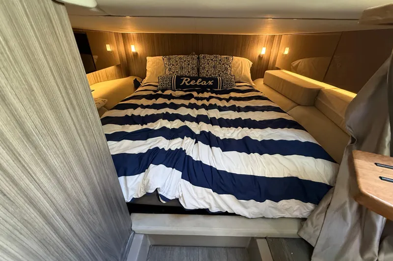 Slide: The Image of Luxurious cabin interior of 2022 Sea Ray SLX 400 with cozy bed and ambient lighting. - 44