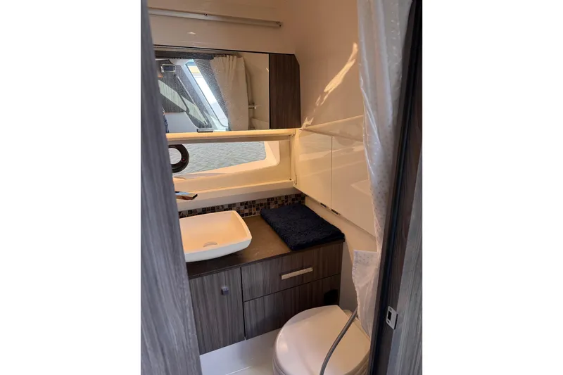 Slide: The Image of 2022 Sea Ray SLX 400 bathroom interior with modern sink and cabinetry. - 45