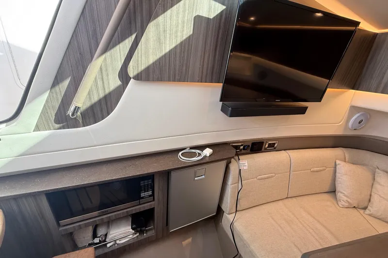 Slide: The Image of Interior of 2022 Sea Ray SLX 400 yacht with TV, seating, and kitchenette. - 46