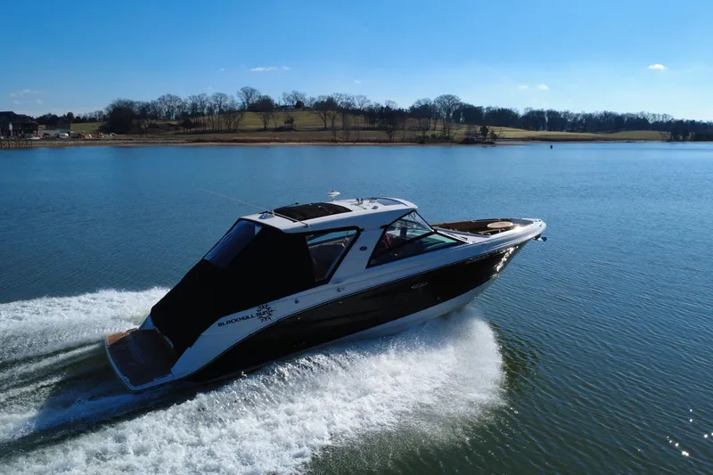 Slide: The Image of 2022 Sea Ray SLX 400 cruising on a serene lake under a clear blue sky. - 6
