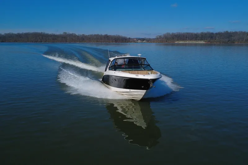 Slide: The Image of 2022 Sea Ray SLX 400 cruising on a calm lake under a clear blue sky. - 7