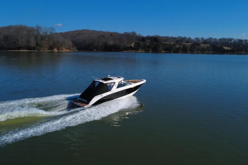 Slide: The Image of 2022 Sea Ray SLX 400 cruising on a serene lake under a clear blue sky. - 8