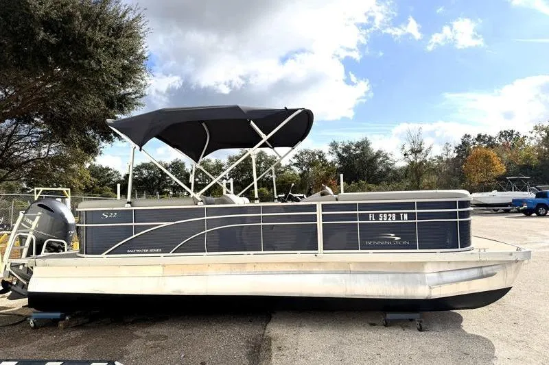 The Image of 2023 Bennington 22SSR pontoon boat with canopy, parked outdoors under a cloudy sky. - 0