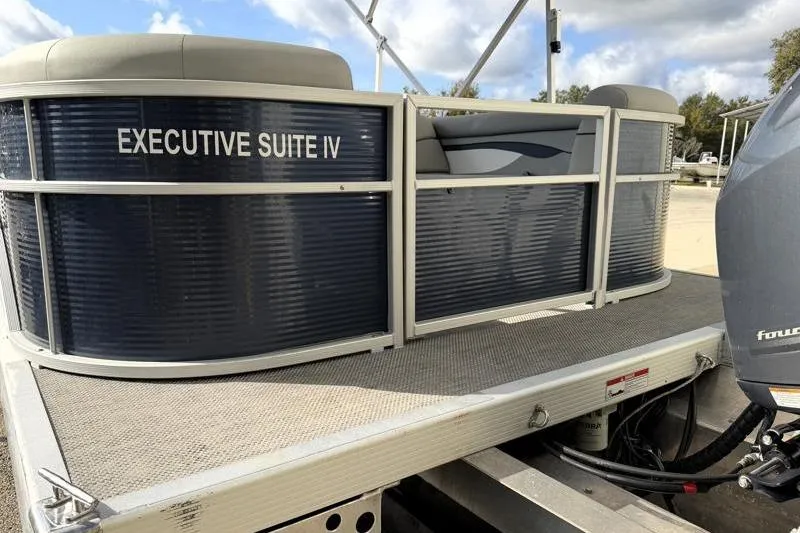 Slide: The Image of 2023 Bennington 22SSR pontoon boat, labeled "Executive Suite IV," docked under a cloudy sky. - 10