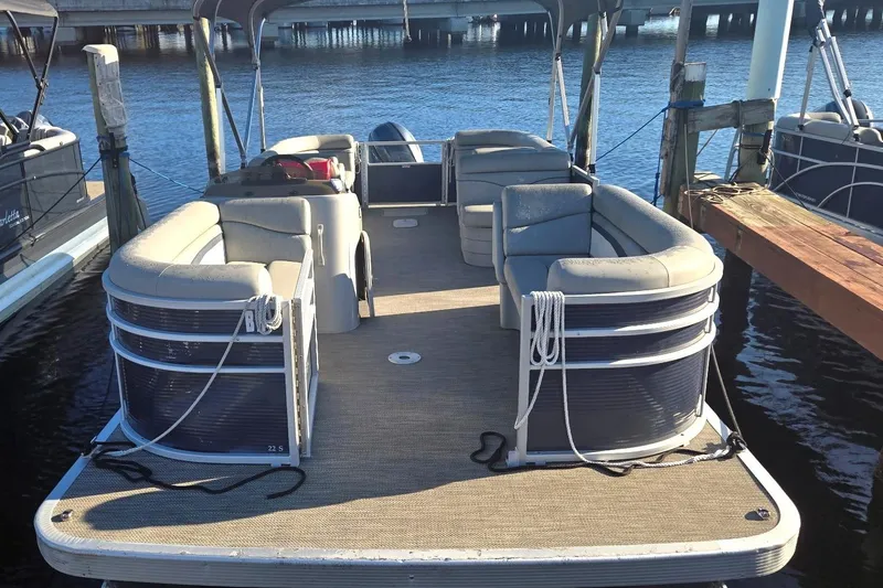 Slide: The Image of 2023 Bennington 22SSR pontoon boat with Yamaha motor, parked outdoors under a blue sky. - 2