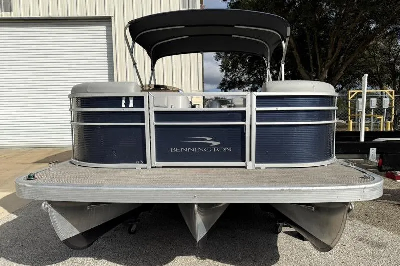 Slide: The Image of 2023 Bennington 22SSR pontoon boat with canopy, parked near a building. - 5