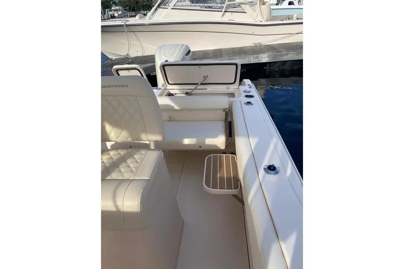 Slide: The Image of 2025 Grady-White Fisherman 236 boat interior near dock, featuring seating and storage. - 17