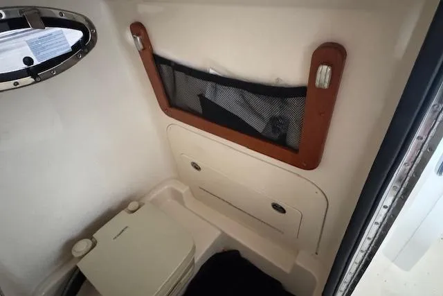 Slide: The Image of 2025 Grady-White Fisherman 236 boat interior with storage and portable toilet. - 24