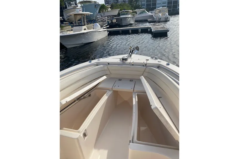 Slide: The Image of 2025 Grady-White Fisherman 236 boat interior with open storage compartments at marina. - 8