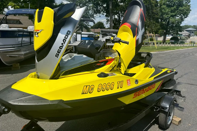 Slide: The Image of 2015 Sea-Doo RXT260 jet ski in vibrant yellow on a trailer, parked outdoors. - 12
