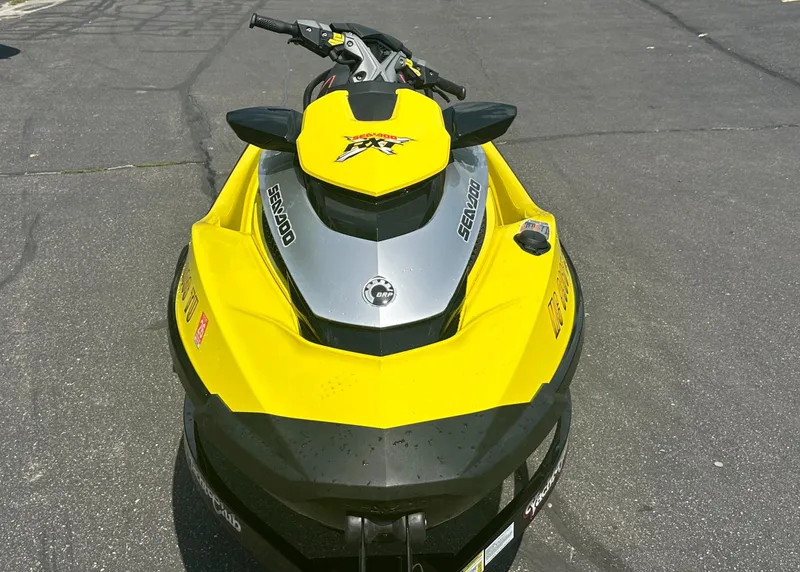 Slide: The Image of 2015 Sea-Doo RXT260 jet ski, yellow and black, parked on asphalt. - 2