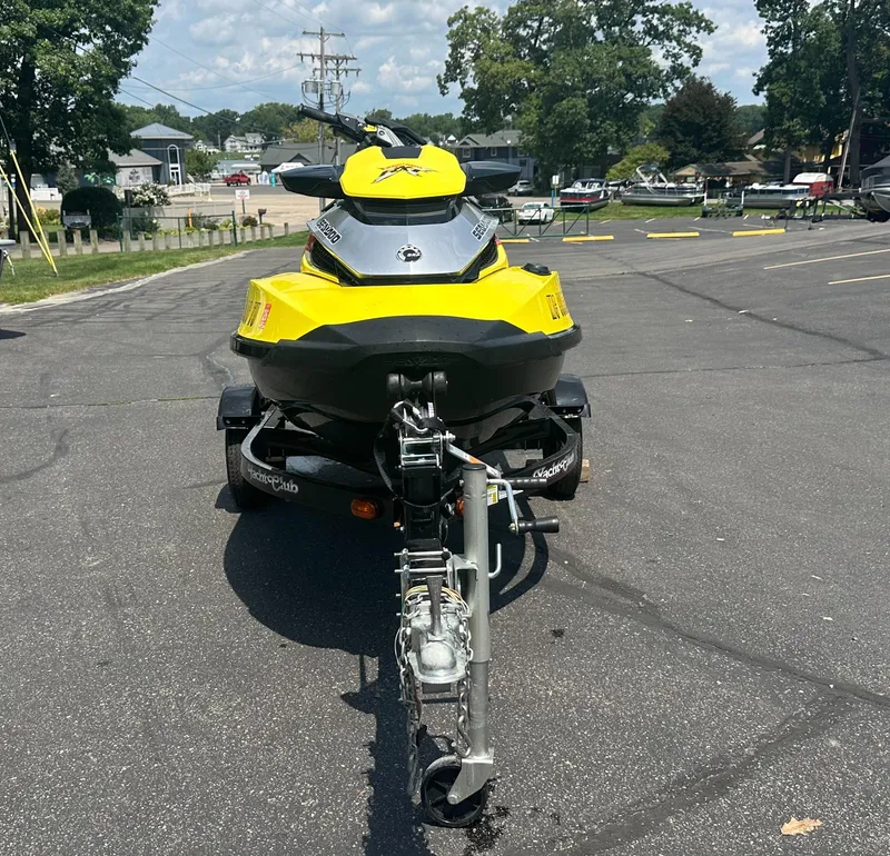 Slide: The Image of 2015 Sea-Doo RXT260 jet ski on trailer, parked in sunny lot. - 3
