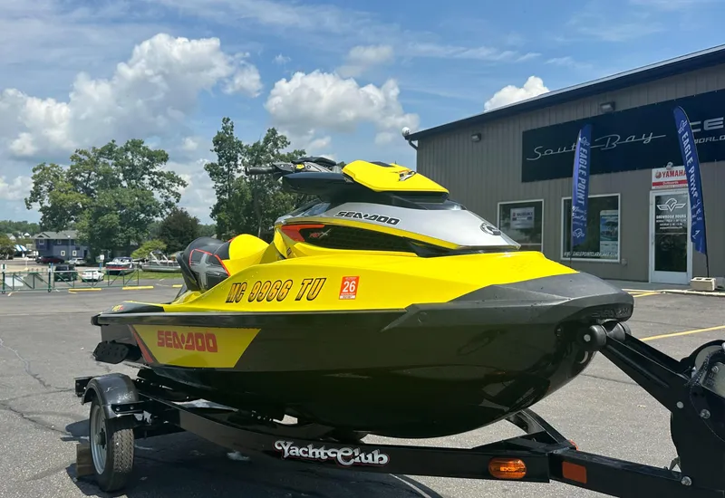 Slide: The Image of 2015 Sea-Doo RXT260 jet ski on trailer, parked outside dealership under blue sky. - 6
