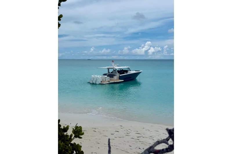 Slide: The Image of 2026 Regal 50 SAV boat anchored in clear turquoise waters near a sandy beach. - 27