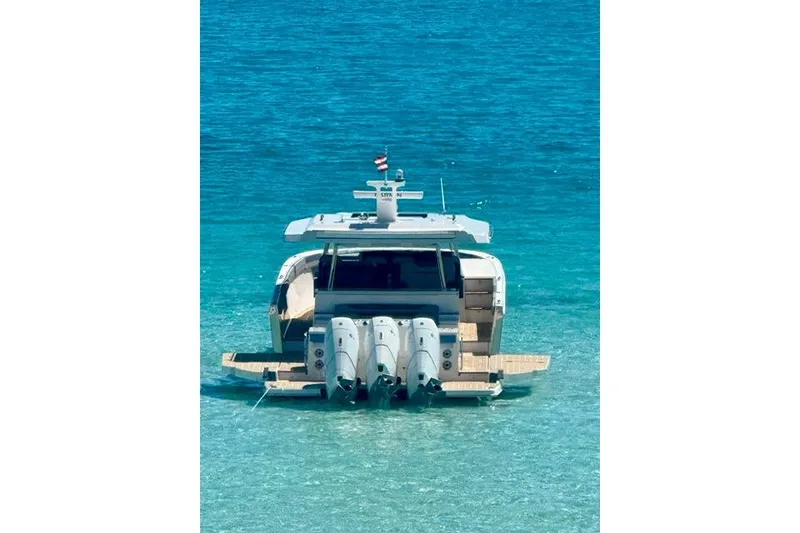 Slide: The Image of 2026 Regal 50 SAV yacht with triple outboard engines in clear blue water. - 35