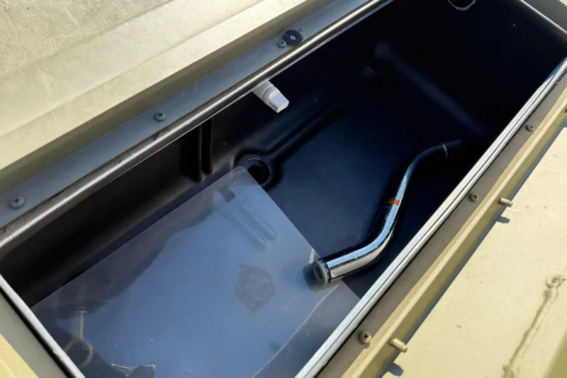 Slide: The Image of Open storage compartment in 2014 Lowe Roughneck 1650 DLX boat with metal pipe inside. - 12