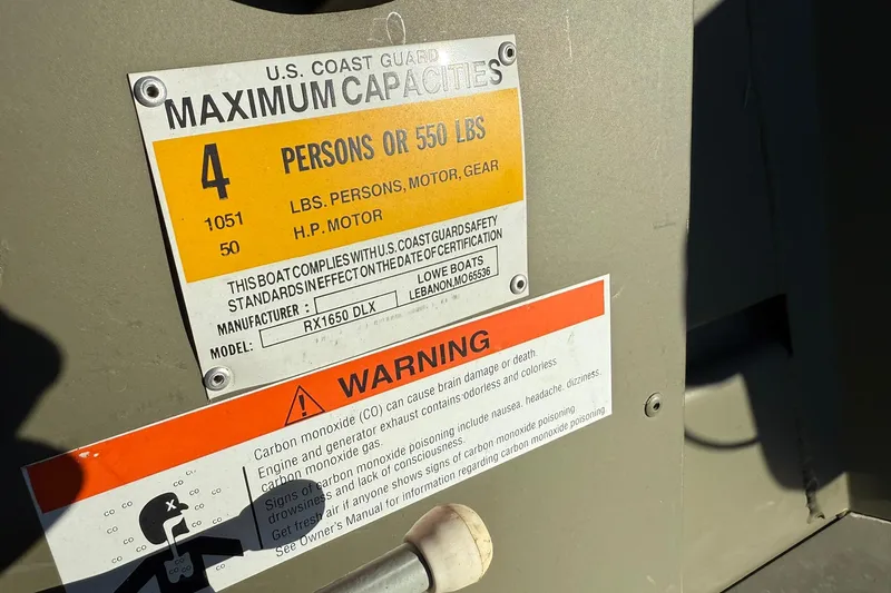 Slide: The Image of 2014 Lowe Roughneck 1650 DLX capacity and safety warning labels. - 13