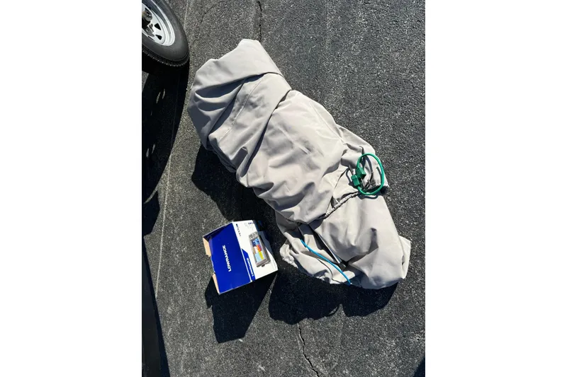 Slide: The Image of Covered Lowe Roughneck 1650 DLX boat with Lowrance box on asphalt. - 17