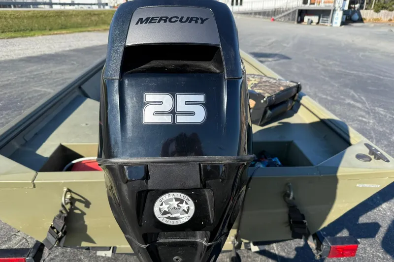 Slide: The Image of 2014 Lowe Roughneck 1650 DLX boat with Mercury 25 outboard motor, parked outdoors. - 5