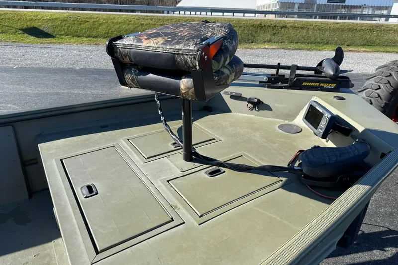 Slide: The Image of 2014 Lowe Roughneck 1650 DLX boat interior with camo seat and control panel. - 9