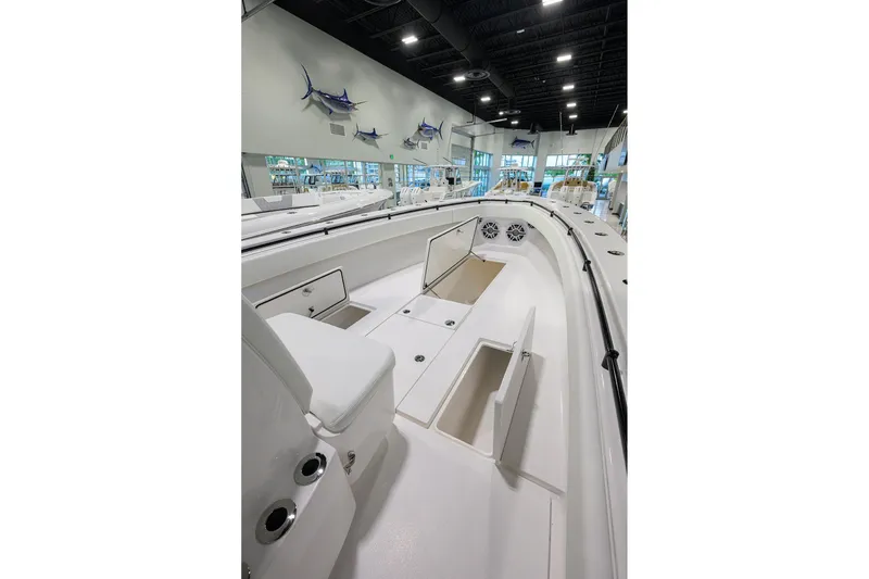 Slide: The Image of 2026 Contender 39 ST boat interior with open storage compartments in a showroom. - 13