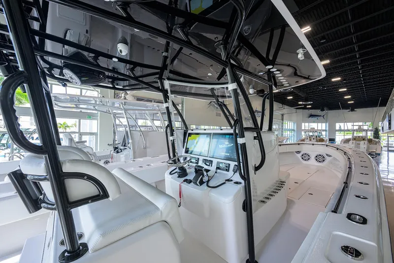 Slide: The Image of 2026 Contender 39 ST boat interior with modern controls and seating in a showroom. - 14