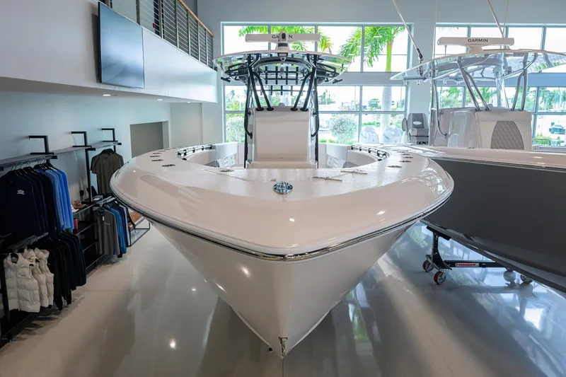 Slide: The Image of 2026 Contender 39 ST boat displayed in showroom, surrounded by apparel and accessories. - 2