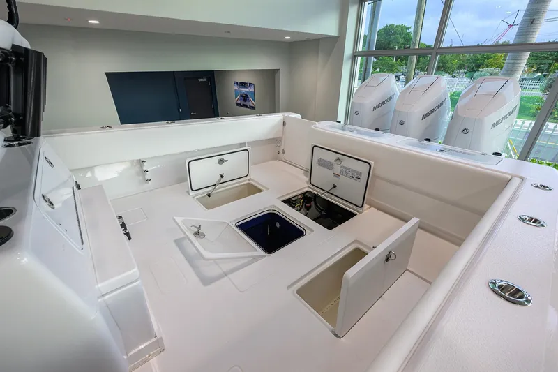 Slide: The Image of 2026 Contender 39 ST boat interior with open storage compartments and Mercury engines. - 22