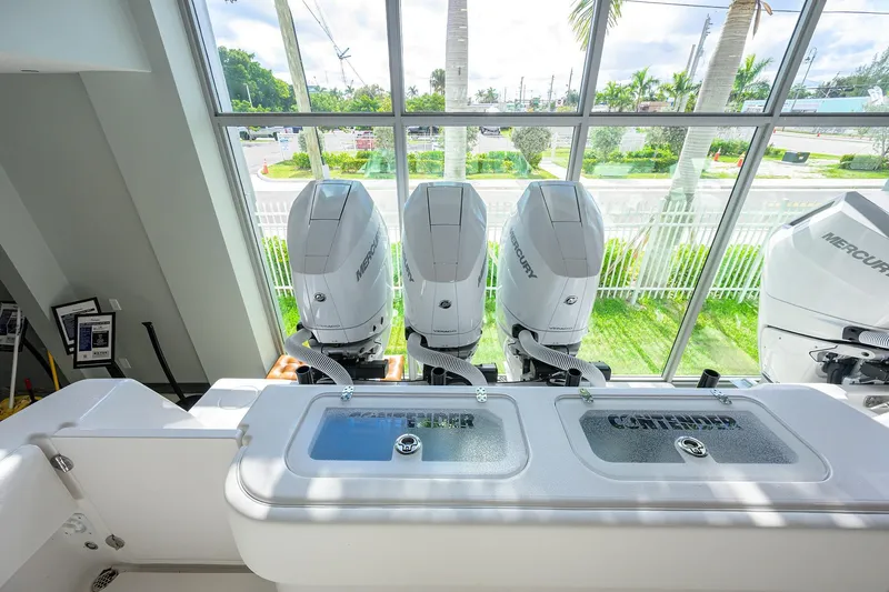 Slide: The Image of 2026 Contender 39 ST boat with triple Mercury outboard engines, viewed indoors. - 23