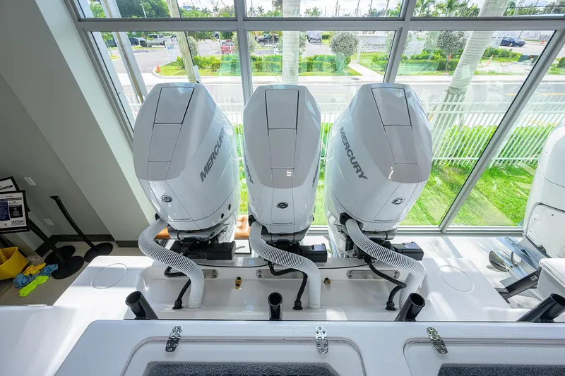 Slide: The Image of Triple Mercury outboard engines on a 2026 Contender 39 ST boat, viewed indoors. - 24