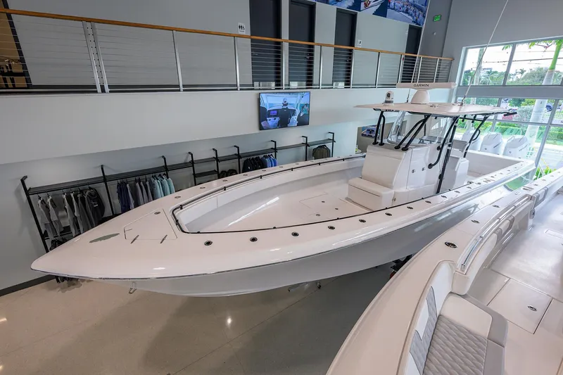 Slide: The Image of 2026 Contender 39 ST boat displayed in a modern showroom. - 4