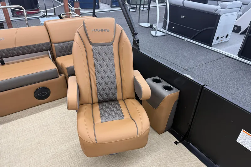 Slide: The Image of 2026 Harris Cruiser 210 boat interior with tan and gray seating, featuring cup holders. - 12