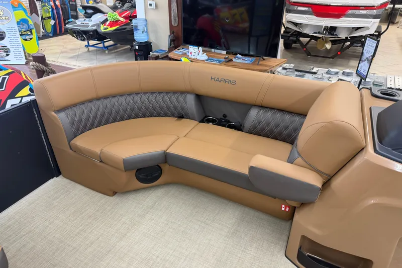 Slide: The Image of 2026 Harris Cruiser 210 boat interior with tan and gray seating in showroom. - 9
