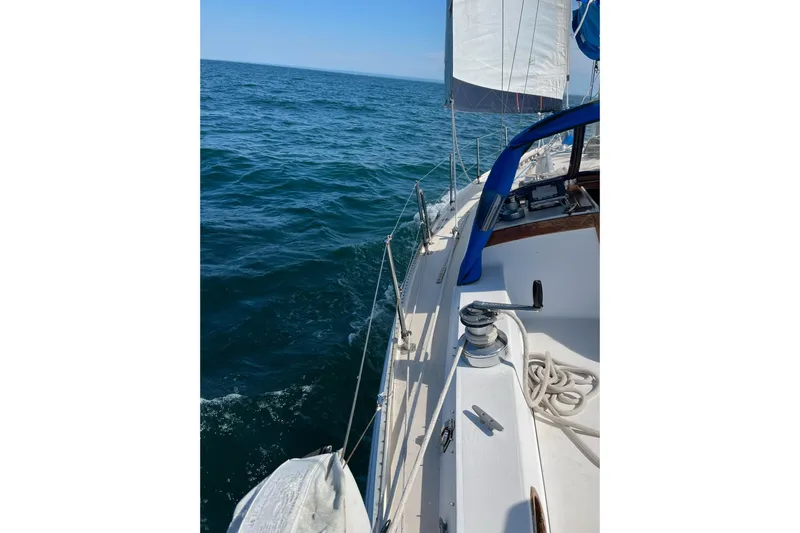 Slide: The Image of Sailing on a 1985 Catalina 36 yacht in open sea, clear skies above. - 11