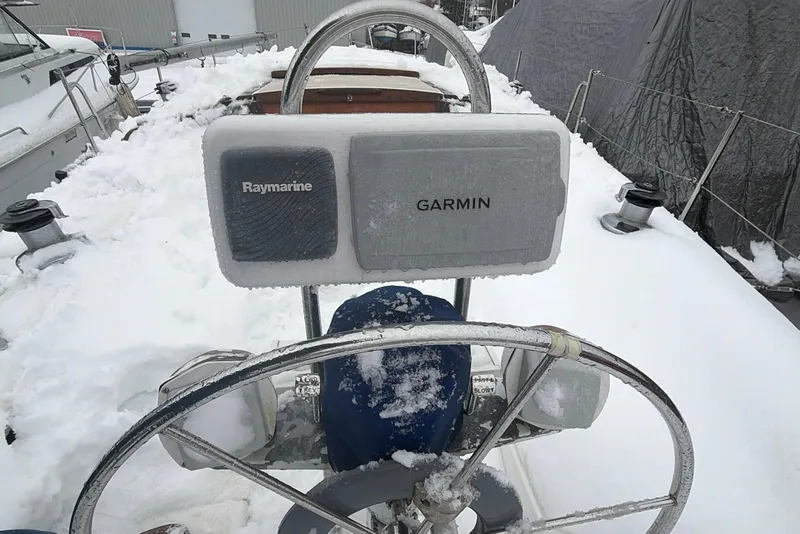 Slide: The Image of Frozen Catalina 36 sailboat cockpit with Raymarine and Garmin equipment, covered in snow. - 12