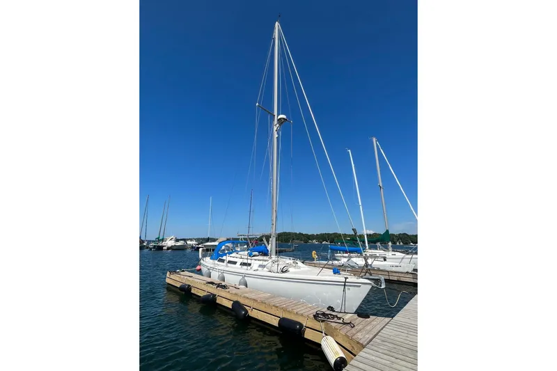 Slide: The Image of 1985 Catalina 36 sailboat docked at marina under clear blue sky. - 17