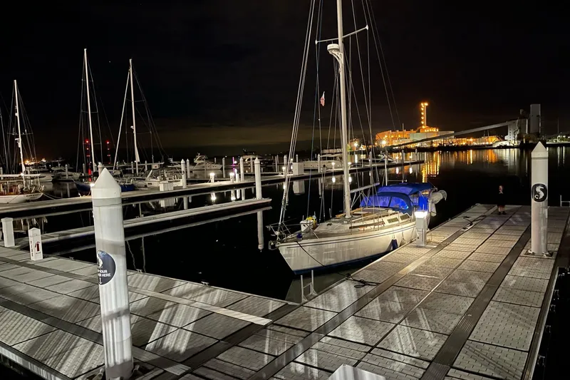 Slide: The Image of Nighttime marina scene with a 1985 Catalina 36 sailboat docked, illuminated by nearby lights. - 21