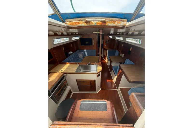 Slide: The Image of Interior of a 1985 Catalina 36 sailboat with wood finishes and blue seating. - 22