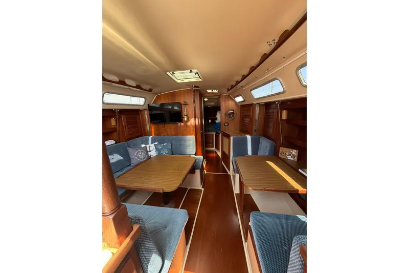 Slide: The Image of Interior of a 1985 Catalina 36 sailboat with cozy seating and wooden finishes. - 23