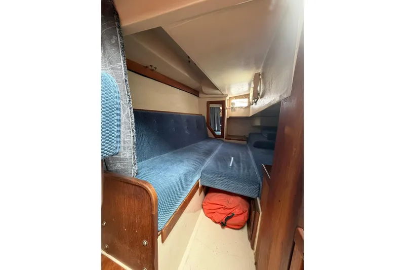 Slide: The Image of Interior cabin of a 1985 Catalina 36 sailboat with blue upholstery and wooden accents. - 24