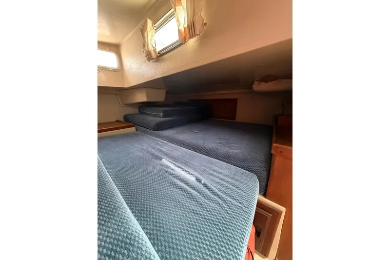Slide: The Image of Interior cabin of a 1985 Catalina 36 sailboat with blue cushions and wooden accents. - 25