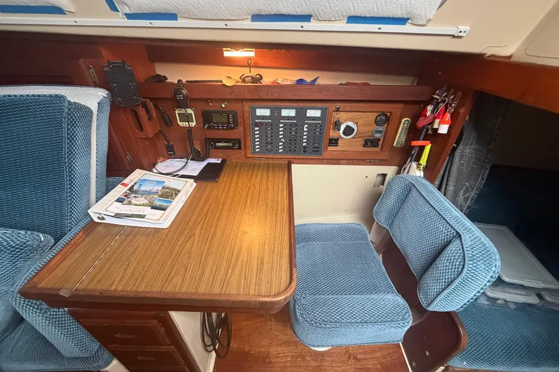 Slide: The Image of Navigation station inside a 1985 Catalina 36 sailboat with blue upholstery and control panel. - 27